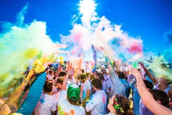 Students toss colored paint powder in the air during a fun run